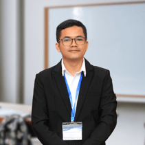 A person wearing a black suit and glasses

Description automatically generated, Picture