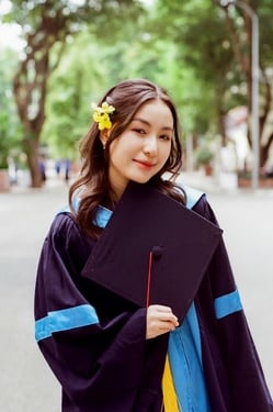 A person in a graduation gown holding a graduation cap

Description automatically generated, Picture