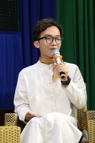 A person in glasses holding a microphone

Description automatically generated, Picture