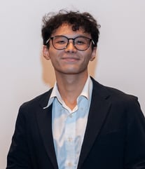 A person in a suit and glasses

Description automatically generated, Picture