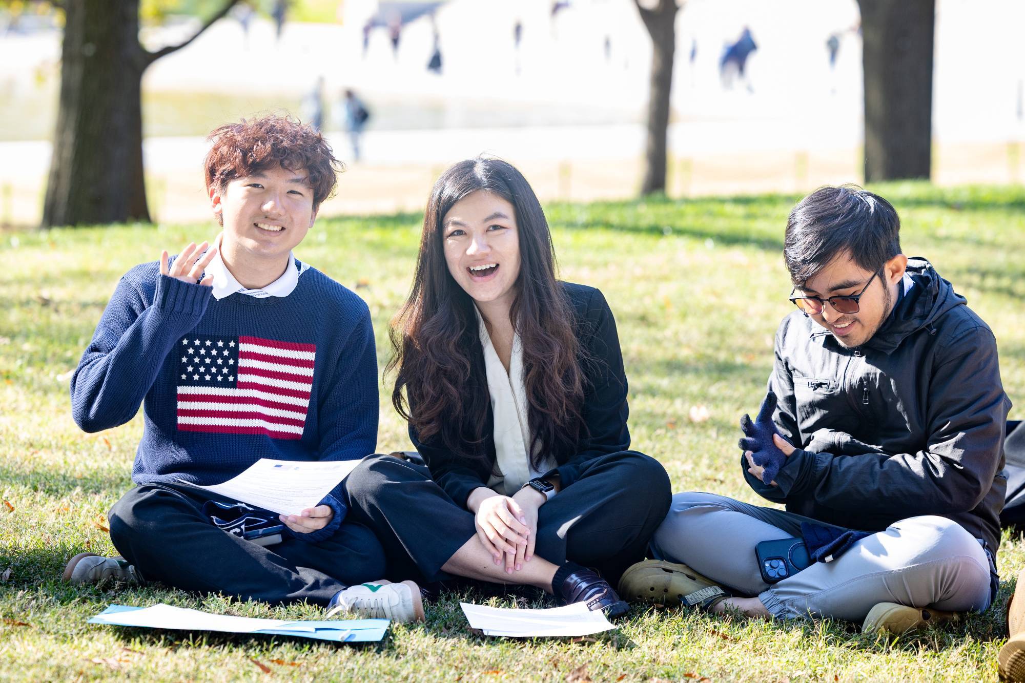 Three YSEALI fellows sitting in the grass laughing